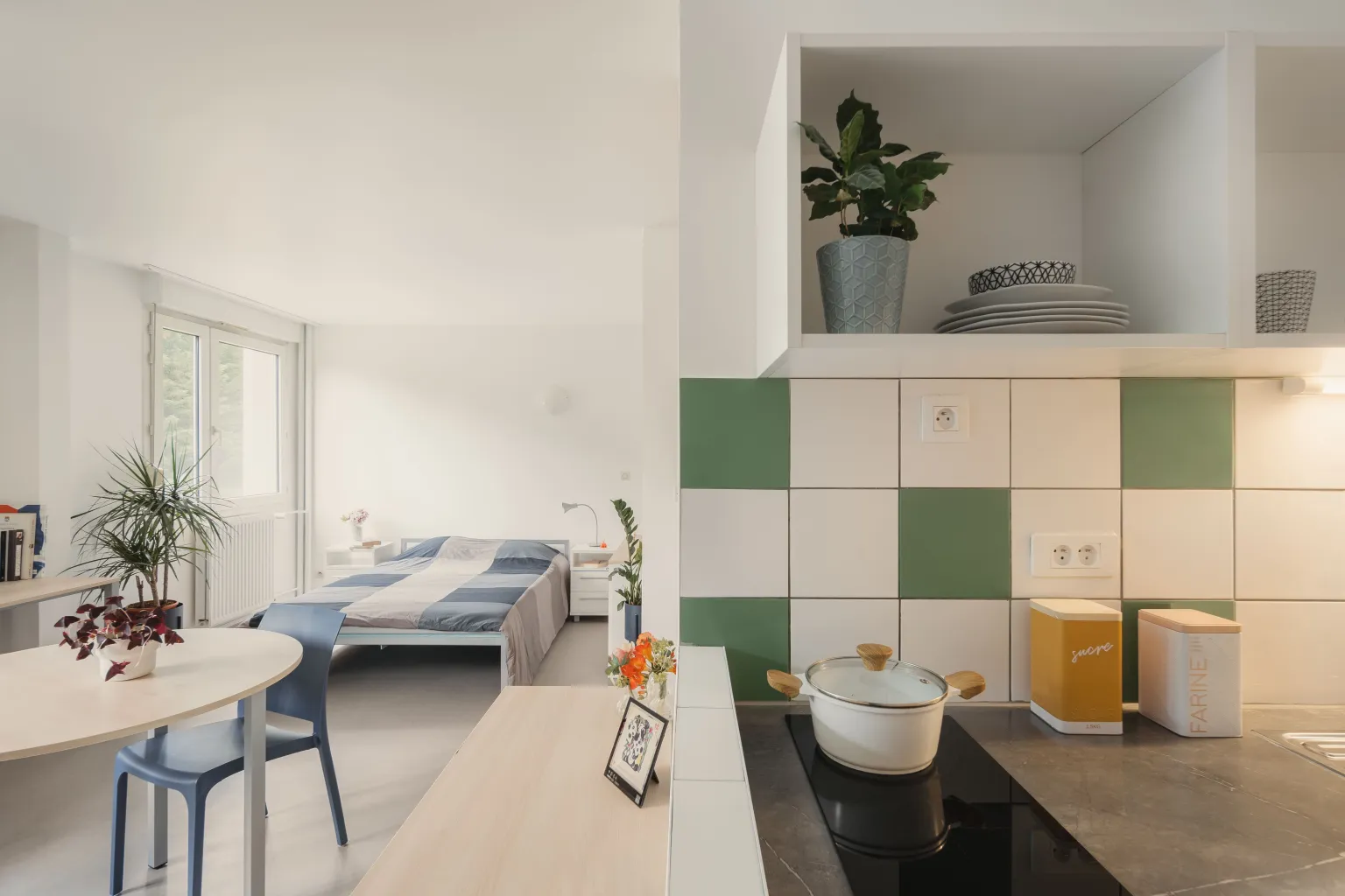 Studio - ADOMA Studio image (from left to right: table, desk, bed, kitchen)