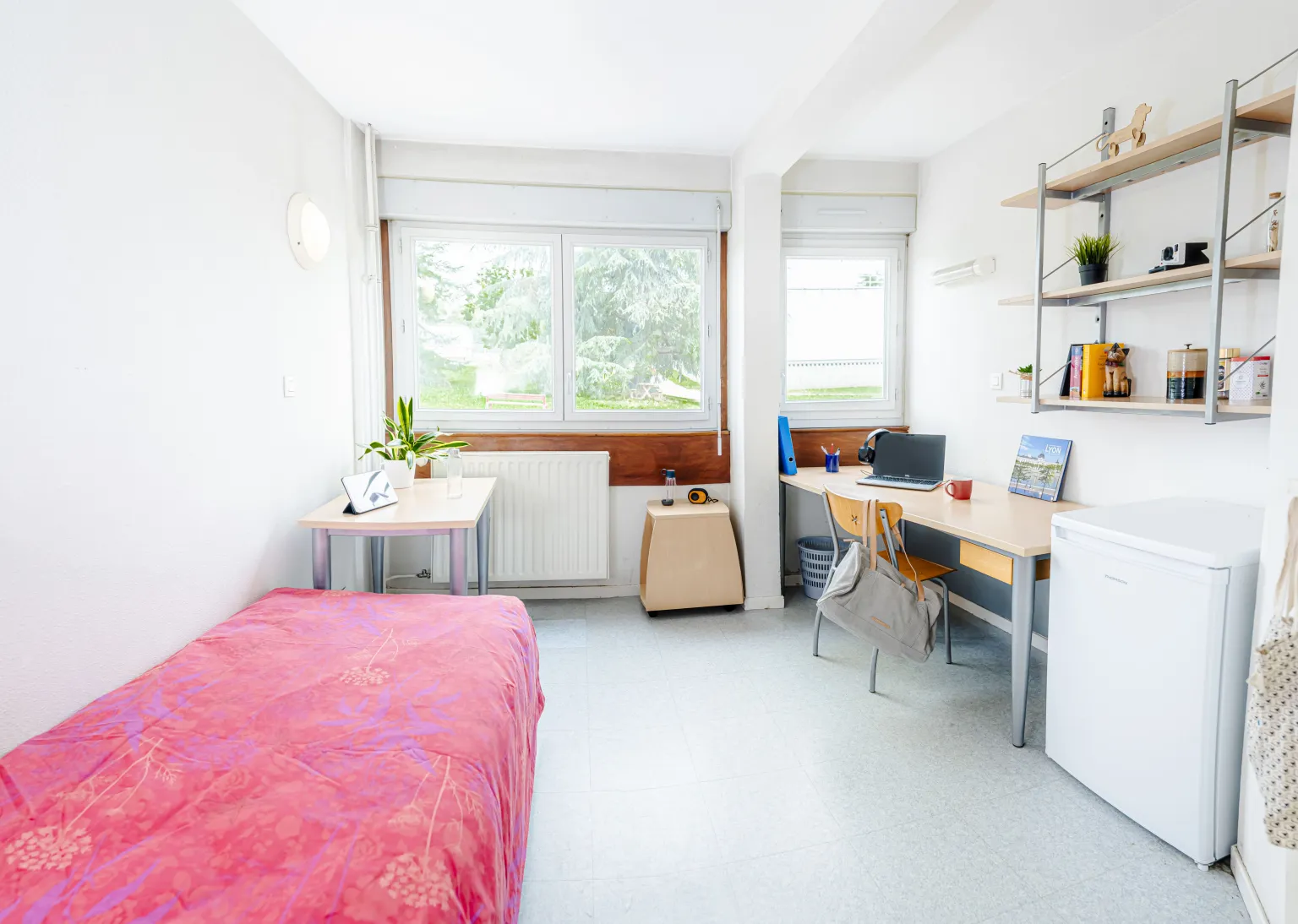 Bedroom - Paul Comparat Image of a bedroom (left to right: bed, table, side table, desk, small fridge)