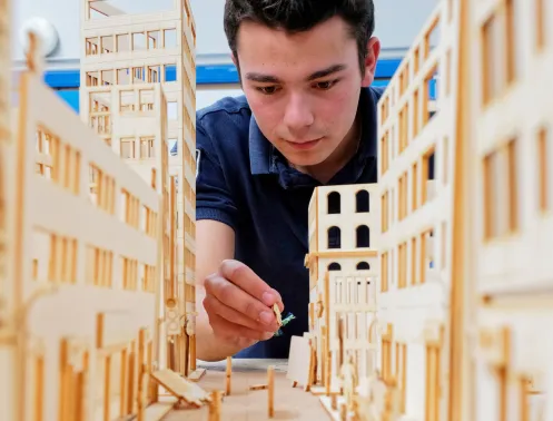 student manipulating an architectural model